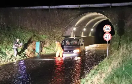 Busje strand in tunnelbak onder N34 bij Eext. Brandweer Annen haalt de bus met de LIER weg — foto 1 van 3