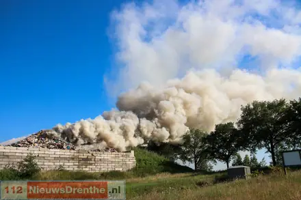 Brandweer uitgerukt voor grote brand in afvalbult op bedrijventerrein in Nieuw-Dordrecht, rookpluim is in wijde omgeving te zien — foto 4 van 5