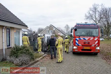 Brandweer blust brand in coniferenhaag in Emmen — foto 1 van 4