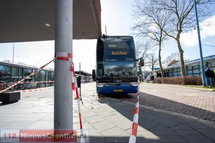Dubbeldekker Qbuzz vast onder uitstekende hoek gebouw in Emmen — foto 1 van 3