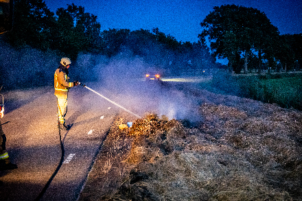 Brandweer blust broei in stro langs weg in Nijeveen — Nijeveen