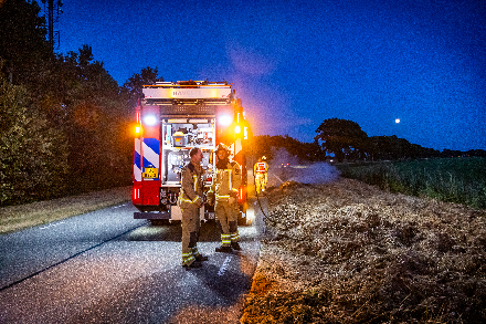 Brandweer blust broei in stro langs weg in Nijeveen — Nijeveen