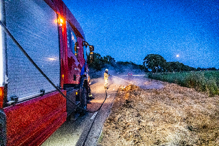 Brandweer blust broei in stro langs weg in Nijeveen — Nijeveen