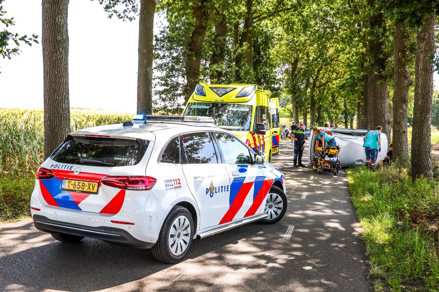 Auto belandt op zijkant na botsing tegen boom in Holsloot, bestuurster naar ziekenhuis