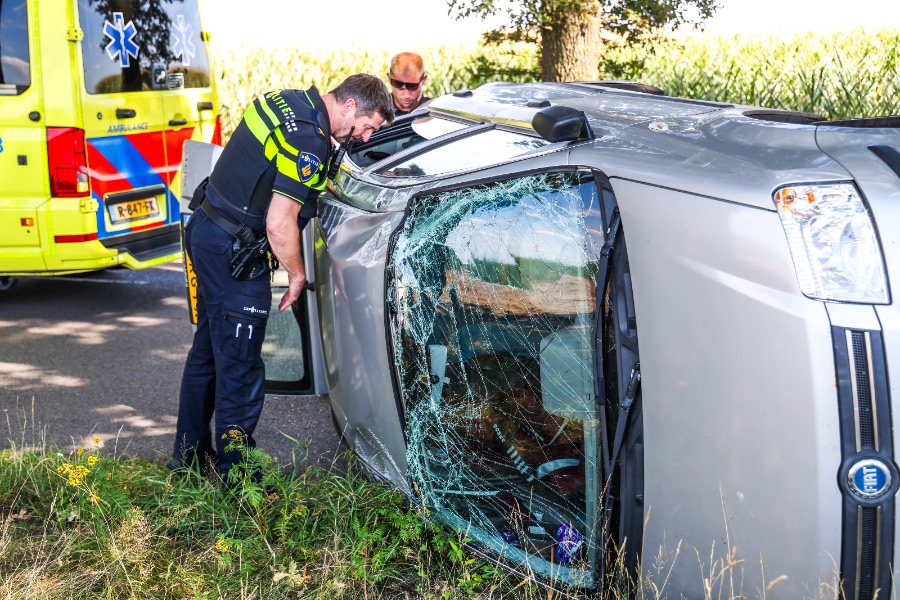 Auto belandt op zijkant na botsing tegen boom in Holsloot, bestuurster naar ziekenhuis